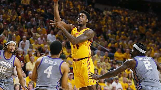 Iowa State Cyclones forward Hason Ward (24) passes the ball between TCU Horned Frogs guard Jameer Nelson Jr. (4) and forward Emanuel Miller (2) during the first half in the Big-12 conference showdown of a NCAA college basketball at Hilton Coliseum on Saturday, Feb. 10, 2024, in Ames, Iowa.